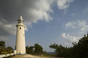 Jamaica, Negril, Afternoon sun lights lighthouse on bluff overlooking Caribbean Sea
