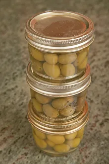 Olive Prints: Three jars of home canned olives on a granite countertop in a kitchen