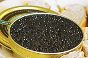 A just open tin of black caviar with slices of bread Caviar et Prestige'