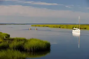 Kayaker Prints: Kayakers paddle past a sailboat at anchor between Great Island and the shoreline