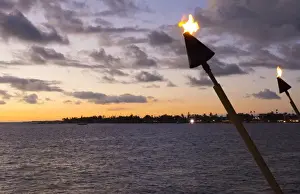 Images Dated 2028: Kona Hawaii Big Island tiki fire light over Ocean at Kailua-Kona beach at sunset