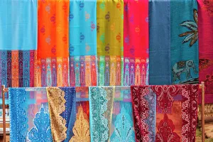 Tom Haseltine Prints: Laos, Luang Prabang. Colorful textiles, possibly scarves, for sale
