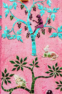 Laos, Luang Prabang. Mosaic mural depicting a monkey in a fruit tree