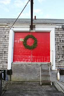 Images Dated 25th December 2014: A large wreath adorns red doors on a building at Barnstable Harbor, Barnstable, Cape Cod