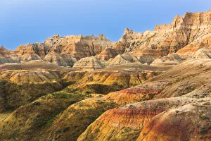 Strip Prints: Layers of striated round hoodoos lead to soaring sharp peaked hoodoos reflecting sunset oranges against the deep blue
