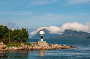 Waterscape Prints: A lighthouse perches on a rocky promontory and reflects on Holandsfjorden
