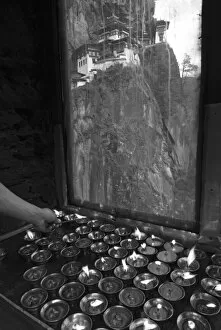 Images Dated 17th November 2006: lighting candles at Taksang Monastery near Paro, Bhutan