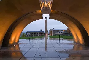 Lights throw golden light on the concrete arched entrance to Mission Hill Family