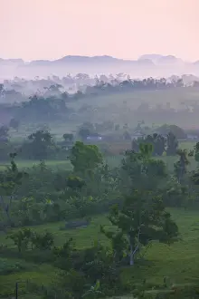 Limestone hill, farming land and village house in morning mist, Vinales Valley, UNESCO