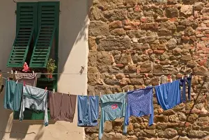 Open Market Prints: A line of clothes dries between buildings near an open air market in Figline