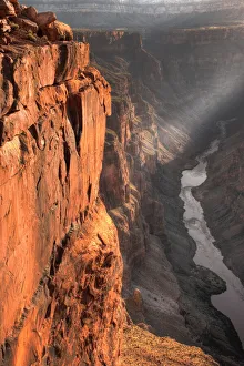Chasm Prints: A lone ray of light filters through the clouds at sunrise at Toroweap Overlook in