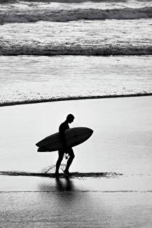 One Person Prints: Lone surfer along the beach coming from the surf