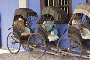 Tire Prints: Malaysia, Penang. Traditional rickshaws lined up next to house