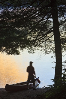 Images Dated 26th July 2010: A man next to his canoe at Zack Woods Pond, Hyde Park, Vermont. Early morning