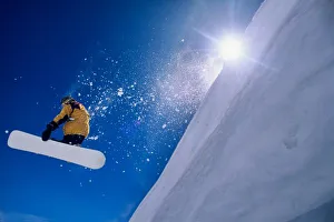 Sport Prints: Man flying through the air on a snowboard with the sun over his shoulder in the Wasatch