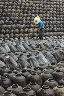 Prints of Man in the middle of big pile of wine jars stacked up at a local rice winery, Wuxi, Jiangsu Province, China Asia Prints: Man in the middle of big pile of wine jars stacked up at a local rice winery, Wuxi