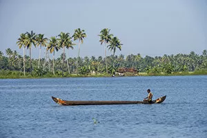 Man rowing a long wooden canoe, Backwaters, Kerala, India