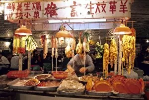 A man works at a night market selling meat and fish in Hong Kong