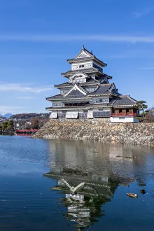 The Matsumoto Castle as seen from the bridge with the city buildings in the background