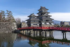 The Matsumoto Castle as seen from the bridge with the city buildings in the background