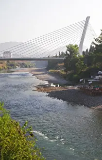 The Millennium Bridge spans Moraca River with cables that form a graphic pattern