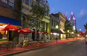 Mobile Alabama downtown traffic on Dauphin Street at twilight with Trustmark Skyscrapper