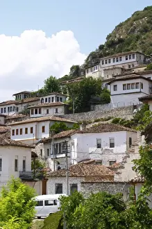 Albania Prints: The modern lower part of the village crawling up the hillside with white washed ottoman