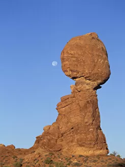 Full moon descending above Balancing Rock in Arches National Park, Utah