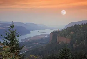 Multnomah County Prints: The moon hangs in the sky above the Vista House, high on Crown Point as sunset falls