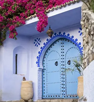 Moroccan Prints: Morocco, Chefchaouen. Bougainvillea blossoms frame an ornate blue door
