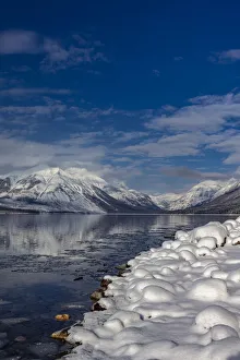 Mountains reflect in wintry Lake McDonald in Glacier National Park, Montana, USA