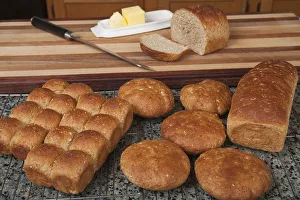 Roll Prints: Multigrain rolls, buns and loaf with a slice cut off, with butter and a bread knife