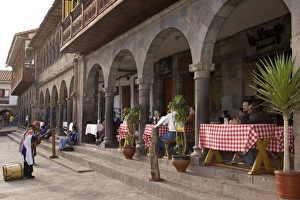 Images Dated 15th May 2005: Musician playing for tourists having lunch on patio, Plaza de Armas, Cuzco, Peru