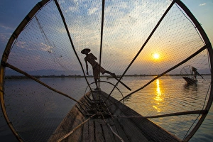 Paddle Prints: Myanmar, Inle Lake. Fishermen rowing at sunset