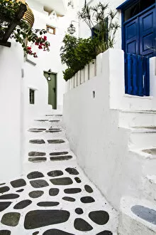 Greece Collection: Mykonos, Greece. Rock and stucco patio and stairs leads to painted doors