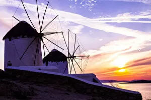 Greece Collection: Mykonos, Greece. Two Windmills with a golden, pink, and blue sunset on the Aegean Sea