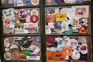 Sticker Prints: Namibia, Solitaire. Close-up of a bank of windows plastered with stickers