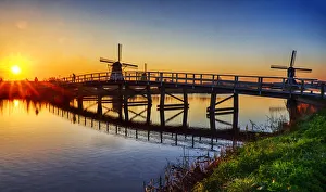Clear Sky Prints: Netherlands, Kinderdijk. Windmill and bridge along the canal at sunrise