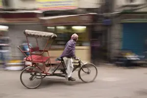 New Delhi Prints: New Delhi, pedicab, rickshaw speeds down the narrow streets. Editorial Only