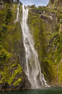 Images Dated 17th January 2012: New Zealand, South Island, Fiordland National Park. Waterfall cascades into Milford Sound