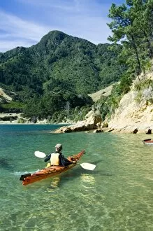 New Zealand, South Island, Marlborough Sounds. Chris Jones sea kayaking in Titirangi Bay