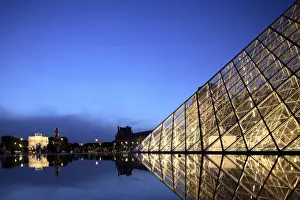 Louvre Prints: The night view of the glass Pyramid of Musee du Louvre with Arc de Triomphe du Carrousel