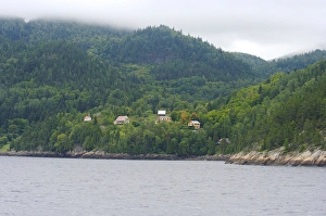 North America, Canada, Quebec, Saguenay. Houses and a church on misty hills near