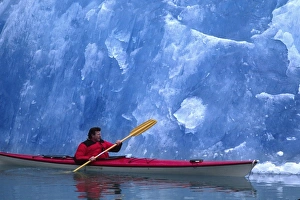 Paddle Prints: North America, USA, Alaska, Tracy Arm. Art Wolfe in a kayak beside blue glacial ice. (MR)