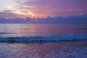 Images Dated 25th September 2010: North America, USA, Georgia, Tybee Island. Sunrise clouds refecting on incoming waves