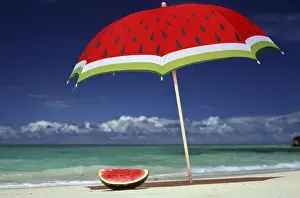 North America, USA, Hawaii. Watermelon and matching umbrella on beach
