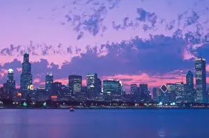 North America, USA, IL. Chicago skyline at dusk with Lake Michigan in foreground