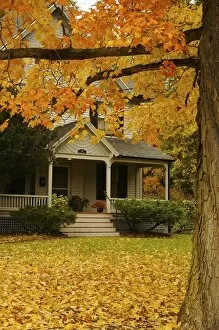 North America, USA, Massachusetts, Amherst. Autumn leaves framing the front porch of an old house