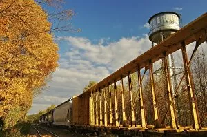 North America, USA, Massachusetts, Erving. Train, water tower, and fall foliage