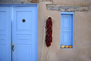 North America, USA, New Mexico. Adobe Blue Door and Hanging Chilis